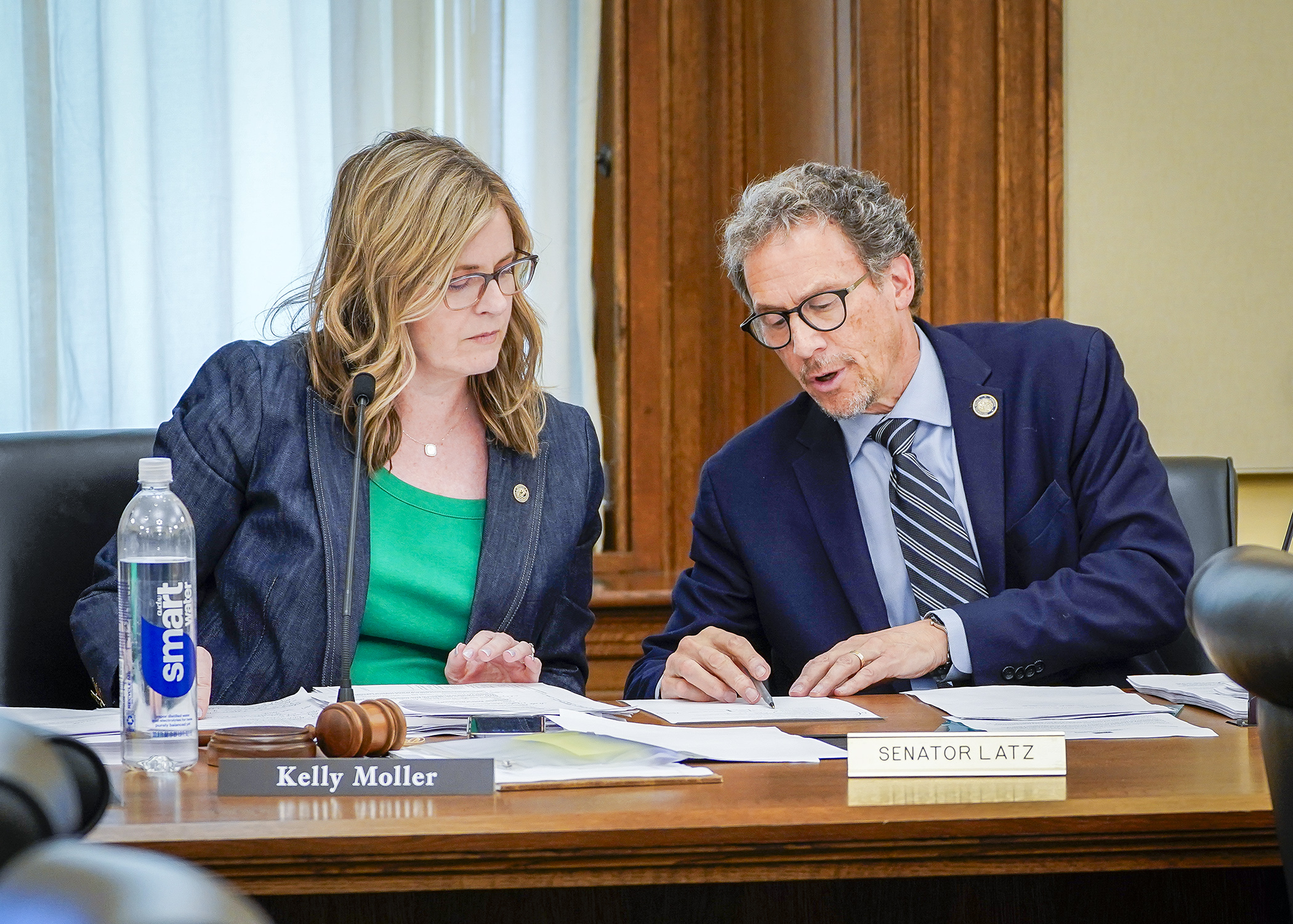 Rep. Kelly Moller and Sen. Ron Latz confer during Friday’s conference committee on the judiciary, public safety, and corrections supplemental budget bill. (Photo by Andrew VonBank)